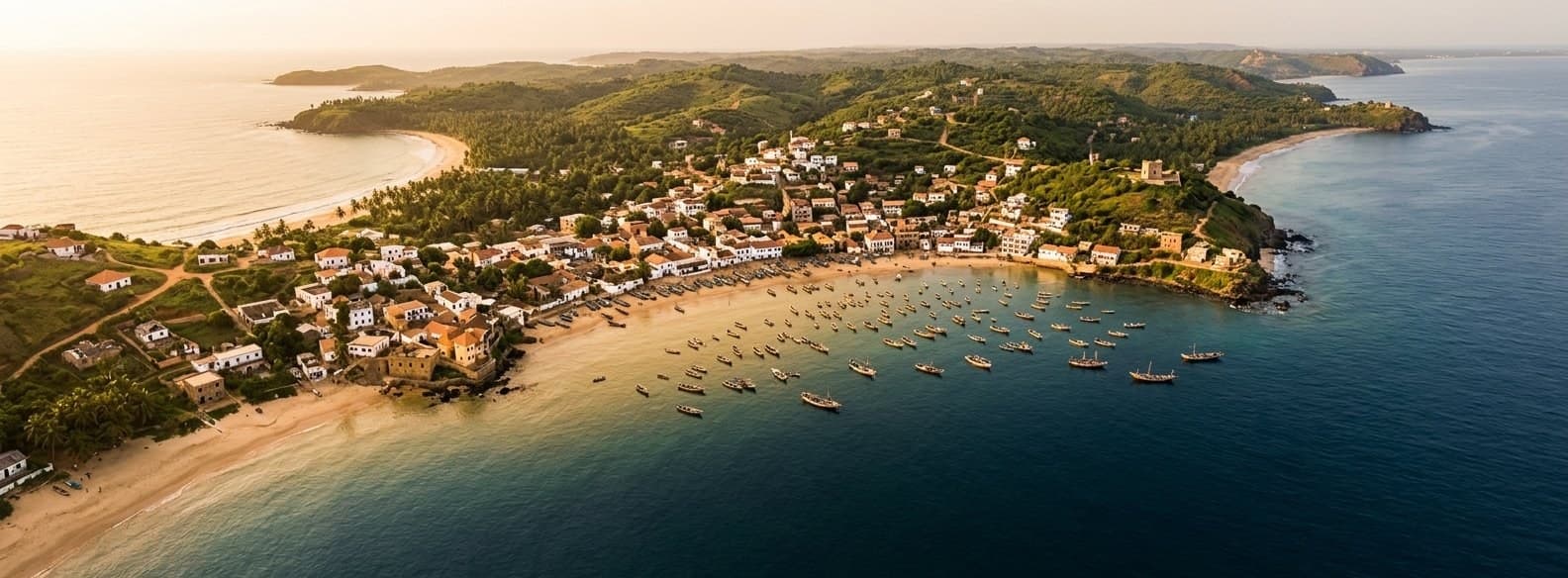Aerial view of a coastal bay with turquoise water meeting green shores